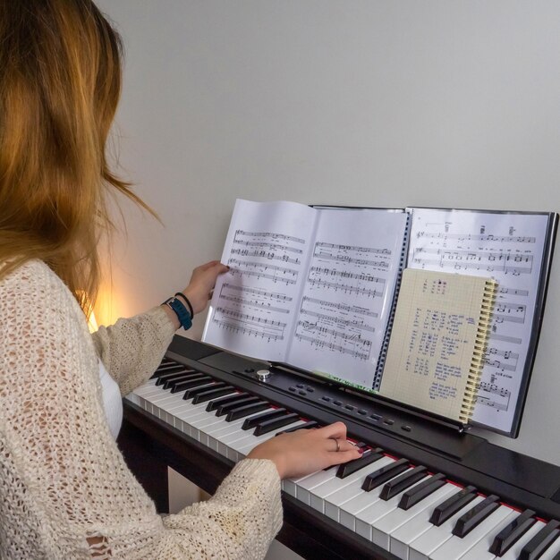 young blonde woman placticing with piano touching music sheet 491380 74